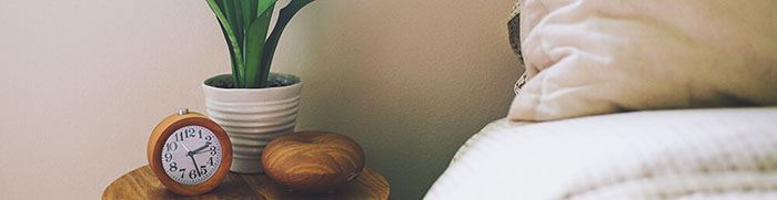 Bedside table with clock and potted plant